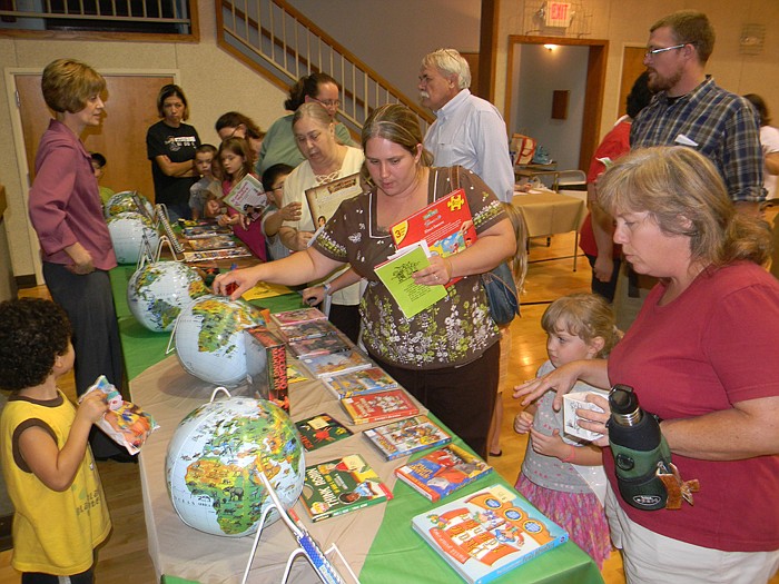 Members of Wood Place Public Library's Summer Reading Program shop for books and other items   at the Globetrotter Fair Market held at United Church of Christ Thursday, Aug. 11, which kept with the program's theme of "One World, Many Stories," in which the children traveled to 11 worldwide locations through books, programs and crafts.