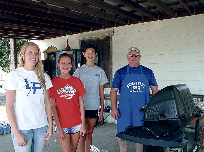 From left, California High School Lady Pinto basketball players Meleigha Caudel, Taylor Lehman and Paige Halsey take a break from working at the annual Lady Pinto Hoops Association Golf Tournament Friday at the California Country Club, while Jay Gump, at right, grills brats and hamburgers for participants of the tournament.