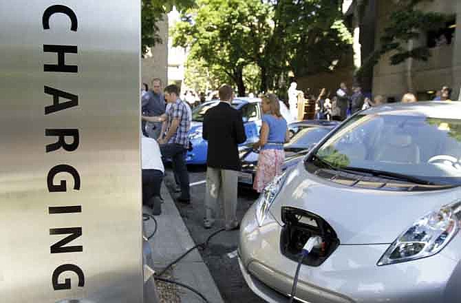 A Nissan Leaf is plugged into a charging station during the dedication of Electric Avenue on the Portland State University campus in Portland, Ore. Tuesday, Aug. 16, 2011. One block of a street running through the campus features seven EV charging stations from six manufacturers, including a quick charge station where students and visitors can plug in electric cars, bicycles, trucks and motorcycles.