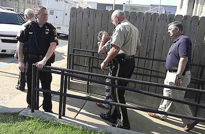 Shawn Morgan covers his head as he is led from a Dunklin County courtroom by Sheriff Bob Holder Tuesday, Aug. 16, 2011, in Kennett, Mo., after his arraignment was rescheduled to allow him time to find an attorney. Police say Morgan has confessed to suffocating Breeann Rodriguez, 3, after finding the child at his backyard swimming pool in Senath. He told police he threw her body in a floodway ditch near the Mississippi River.