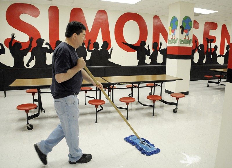 Brad Myers dry mops the cafeteria floor at Simonsen Freshman Center. The award winning custodial staff at the school has been busily preparing for the start of the upcoming school year.