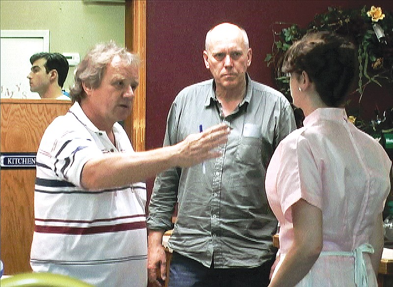 Director Werner Schweitzer (left) speaks with film extras during a rehearsal Wednesday evening at Finally Tammy's. Schweitzer is directing the Swiss film "Ver Liebte Fienes."