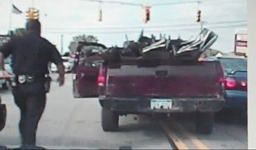 This screenshot from a police car dash video shows an officer in Roseville, Mich., as he stops a pickup truck on Thursday. The pickup had no working brakes and the driver was attempting (unsuccessfully) to stop at intersections by sticking his foot out of the vehicle onto the pavement. VIEW EMBEDDED VIDEO BELOW.