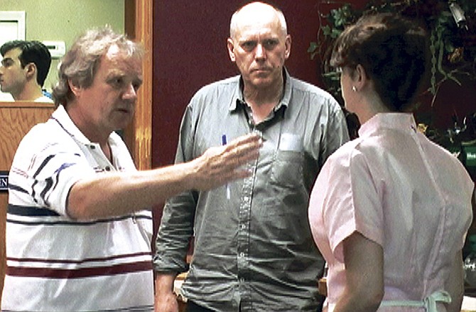 Director Werner Schweitzer, left, speaks with film extras during a rehearsal Wednesday evening at Finally Tammy's in Fulton. Schweitzer is directing the Swiss film "Ver Liebte Fienes." 