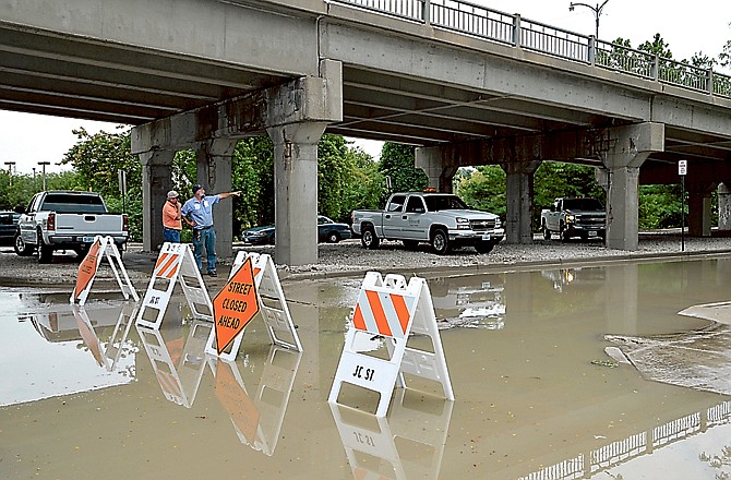 City and Missouri American Water Company personnel discuss how to repair a ruptured irrigation line that flooded Missouri Boulevard under the High Street viaduct.