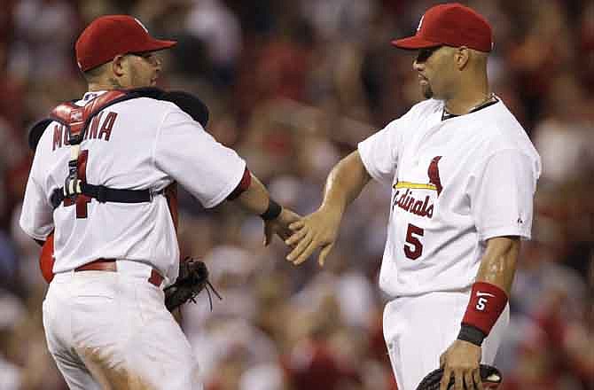 St. Louis Cardinals first baseman Albert Pujols (5) celebrates with catcher Yadier Molina (4) after beating the Chicago Cubs in a baseball game, Friday, July 29, 2011 in St. Louis.