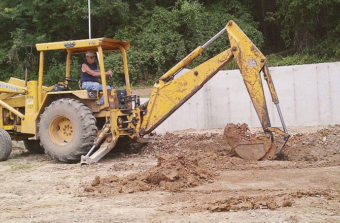 Charlie Schmid works to move dirt at the site of the new Portland Community Building. Community Association officials say they have the funds to put up the exterior of the new structure, but not to complete the project. The original building burned Aug. 13, 2010.