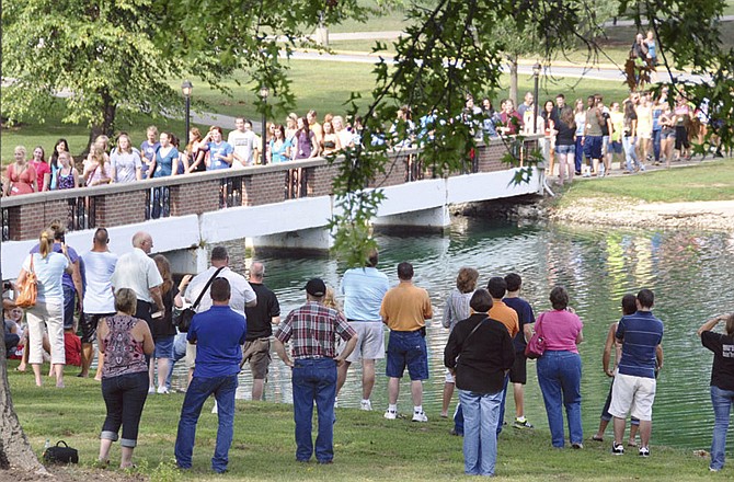 In this Aug. 23, 2011 photo, new William Woods University students cross the Senior Lake Bridge while family and friends watch during a traditional Ivy Ceremony on the Fulton campus.