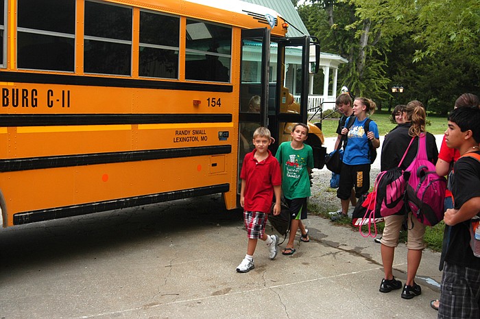 Students for Clarksburg C-II School leave the bus as high school students wait to get on the bus to go to high school.