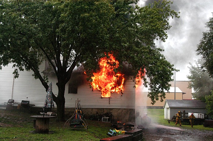 Flames shoot from a window of a house on South East Street in California minutes after the report of a fire with heavy smoke was reported on Tuesday, Aug. 16. The residence, especially a back bedroom, sustained heavy damage in the fire which was of undetermined origin.