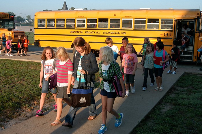 Elementary students leaqve the bus and prepare to enter the California Elementary School on Thursday, Aug. 18, for the first day of school.