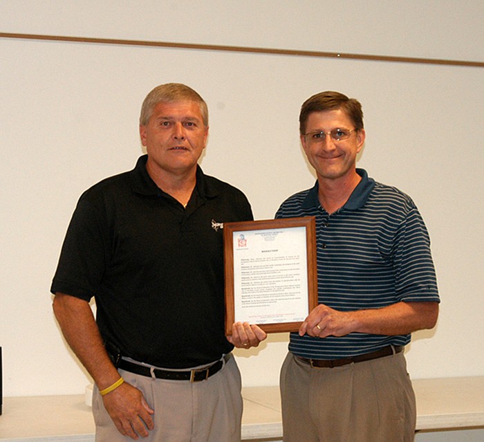 Marty Albertson, left is presented with a Resolution by Steven Burger, president of the California R-I School Board. The Resolution recognizes the achievements of Albertson in the years he served as superintendent before retiring at the end of June. Albertson is now head football coach. 
