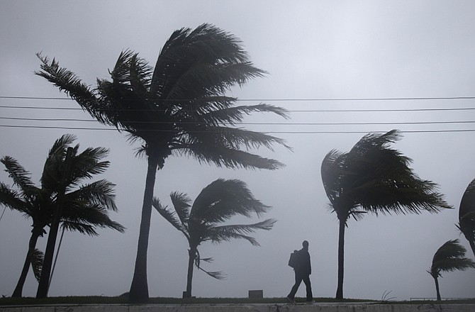 A man walks along a seaside park Thursday as Hurricane Irene passes to the east of Nassau on New Providence Island in the Bahamas.