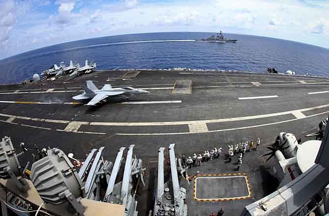 In this photo taken on Aug. 13, 2011, a U.S. Navy fighter attack aircraft F/A18E Super Hornet lands on the deck of USS George Washington (CVN73), off southern coast of Vietnam in South China Sea. Less than a week after China launched its first aircraft carrier, the U.S. has showed off its own big-boy supercarrier to former enemy Vietnam. The visit comes as smaller Asian nations become more jittery amid Beijing's burgeoning maritime ambitions. 