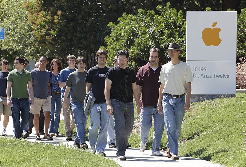 Apple employees walk between buildings Thursday at Apple headquarters in Cupertino, Calif., a day after Apple co-founder Steve Jobs announced his resignation.