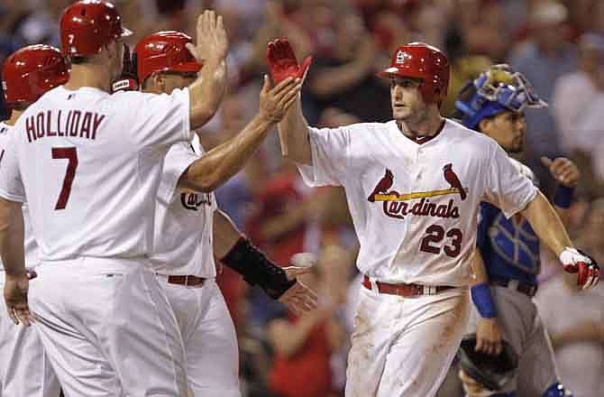 St. Louis Cardinals' David Freese (23) celebrates with teammates Matt Holliday (7) and Albert Pujols (5), as Chicago Cubs catcher Geovany Soto regroups, after hitting a three-run home run in the fourth inning of a baseball game, Friday, July 29, 2011 in St. Louis.