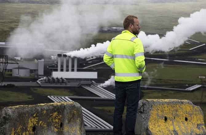 In this July 28, 2011 photo, Bergur Sigfusson, the CarbFix experiment's technical manager, surveys Reykjavik Energy's Hellisheidi geothermal power plant in Iceland. CarbFix's scientists will separate carbon dioxide from the volcanic field's steam and pump it underground to react with porous basalt rock, forming limestone, to see how well the gas most responsible for global warming can be locked away in harmless form. 