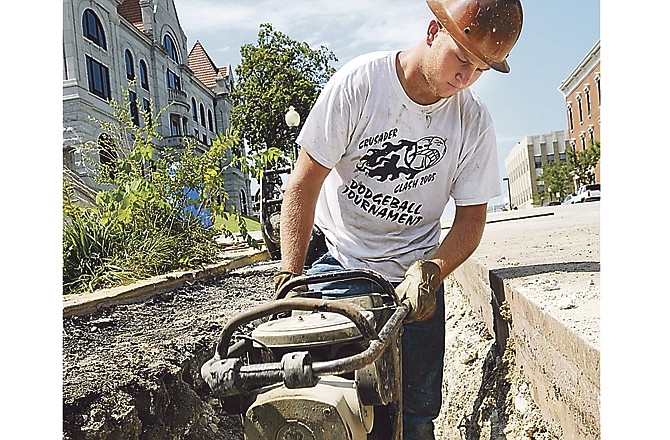 Sean Rogers of Twehous Excavating uses a tamping machine to pack the chat over a new water main on Monroe Street. The Jefferson City Public Works Department is requesting nearly $1 million in increased funding for 2012.
