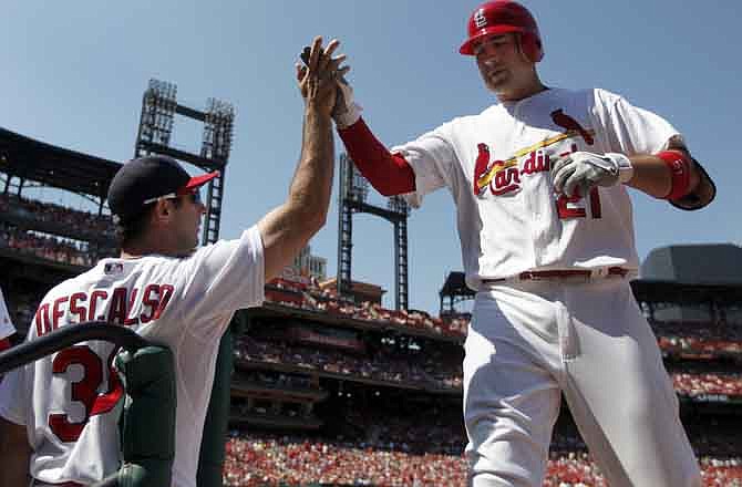 St. Louis Cardinals' Allen Craig, right, is congratulated by teammate Daniel Descalso after hitting a sacrifice fly to score Kyle Lohse during the fourth inning of a baseball game against the Pittsburgh Pirates, Sunday, Aug. 28, 2011, in St. Louis. The Cardinals won 7-4.