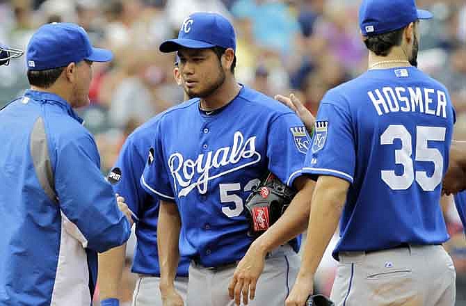 Kansas City Royals starting pitcher Bruce Chen, center, gets a pat on the back from first baseman Eric Hosmer (35) as manager Ned Yost removes Chen from a baseball game against the Cleveland Indians in the eighth inning on Sunday, Aug. 28, 2011, in Cleveland. Chen gave up a lone run in the first and got the win as the Royals defeated Cleveland 2-1. 