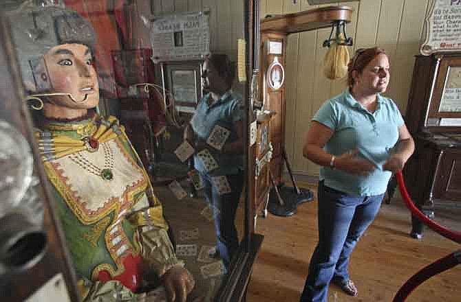 In this July 28, 2011 photo, Janna Norby, curator of collections for the Montana Heritage Commission, stands near an antique Gypsy fortune teller machine, that sat for decades in this Virginia City, Mont., restaurant and has received a multimillion dollar offers from curators including magician David Copperfield. Collectors say the 100-year-old machine that speaks your fortune may be the last of its kind.