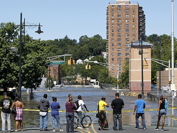 People check out water from the Passaic River covering the intersection of Main Street and Memorial Drive on Tuesday in Paterson, N.J., where the river overflowed its banks following Hurricane Irene.