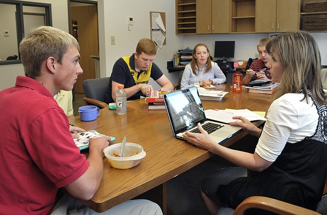 Craig Wehmeyer, left, talks with fellow student government leaders and their faculty advisor, Ginger Luetkemeyer, at right, during a recent Calvary High School Student Government meeting.