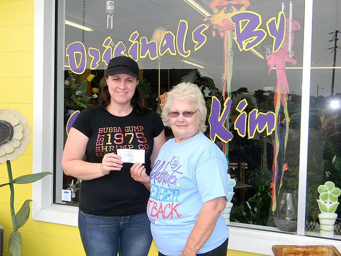 Originals by Sharon and Kim Owner Kim Rimel, left, presents a check of $120.04 to Joy Fischer (Elvis and the Jailhouse Rockers Relay for Life Team), right, which was 10 percent of all sales made the last week of July for Rimel's flower shop.