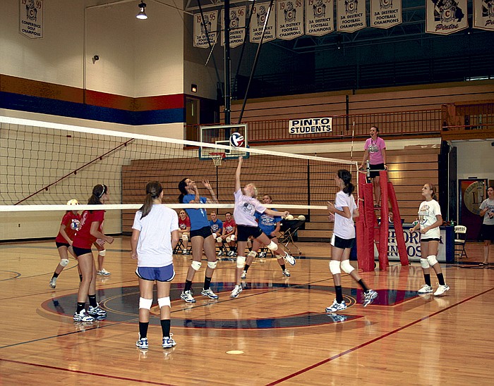 Members of the California High School varsity volleyball team, left of net, scrimmage members of the JVA and JVB volleyball teams, right of net, at the CHS Annual Volleyball Gatorade Scrimmage Aug. 22 at the high school. On the ladder is CHS Head Volleyball Coach Ashley Atteberry. 
