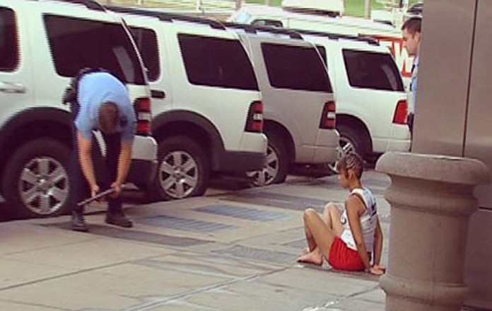 Yokeia Smith, 25, right, sits handcuffed outside the KMOV building in downtown St. Louis on Thursday in a photo taken from KMOV video. On Friday, authorities announced Smith was charged with two first-degree murder counts in the shotgun deaths of her two youngest children. 