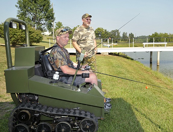 
Mike Lose, near, and Scott Ragar put up their fishing gear as they return to the lodge Friday afternoon. They are both visitors to the String Creek Farms in Centertown for this weekend's "Hunting for Heroes" event. 