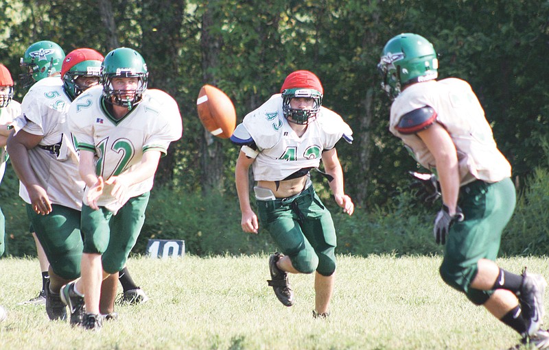 North Callaway junior quarterback Jake Haubner pitches the ball to sophomore wingback Justin Menard during practice at the high school on Wednesday in Kingdom City. Senior tailback Anthony Schaefer (43) trails on the play. The Thunderbirds will be looking for their first win of the season when they travel to California tonight.