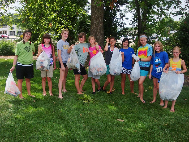 After the girls hold their full bags after they finished picking up trash.                    