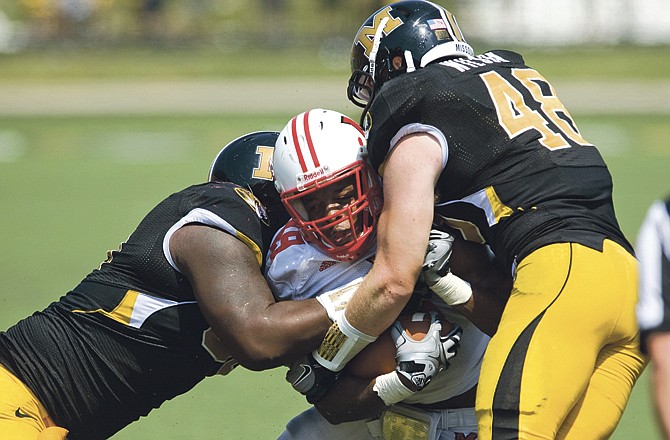 Missouri's Terrell Resonno, left, and Andrew Wilson, right, sandwich Miami Ohio running back Erik Finklea, center, during the second half of an NCAA college football game Saturday, Sept. 3, 2011 in Columbia, Mo. Missouri won the game 17-6. 