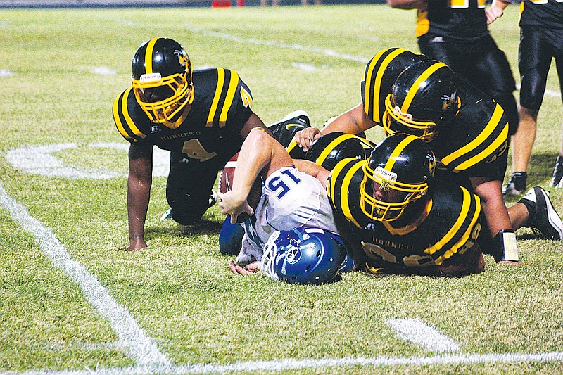 A trio of Fulton tacklers gang up to bring down Boonville senior quarterback Wes Davis on Friday night at Robert E. Fischer Stadium. The Pirates spoiled the Hornets' home and NCMC opener with a 40-3 rout.