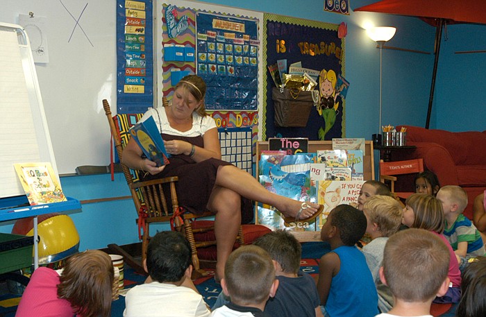 New to the California school is Stacey Edwards, shown reading a book to kindergarten students.