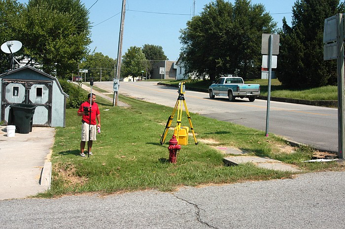 An employee of Bartlett and West Engineering utilizes a "Total Station" to survey the route to be used for storm sewer upgrades.