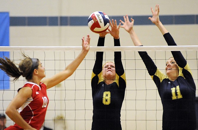 Helias teammates Sidney Lammers (8) and Krista Haslag (11) go up for the block on a hit by Kristin Burnett of the Lady Jays during Tuesday night's match at Rackers Fieldhouse.