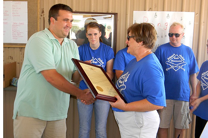 Missouri House Representative Caleb Jones hands Patty Wells, Albert Jobe's daughter, a resoloution passed by the House honoring Jobe during the Dedication Ceremony for the Albert Jobe Ballfield in High Point, Saturday, Sept. 3.