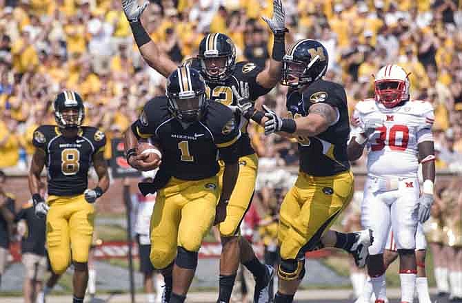 In this Sept. 3, 2011, file photo, Missouri quarterback James Franklin, center, is congratulated by teammates Michael Egnew, top, Wes Kemp, left, and Justin Britt, right, as Miami, Ohio's Evan Harris, far right, looks on after Franklin scored a touchdown during the first half of an NCAA college football game, in Columbia, Mo. More stability on an injury-riddled line would help Franklin make a few more big plays.