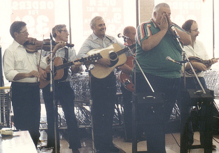 Ron Lutz plays the harmonica with the Rooster Creek Boys at a performance in 1985.