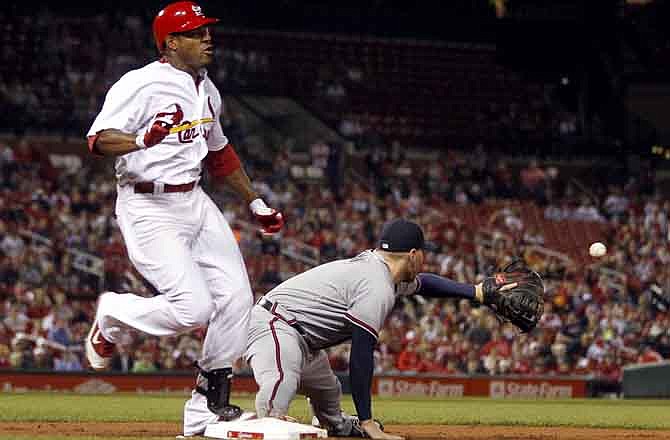 St. Louis Cardinals' Edwin Jackson, left, is safe at first for a single as Atlanta Braves first baseman Freddie Freeman takes the throw during the third inning of a baseball game on Friday, Sept. 9, 2011, in St. Louis.