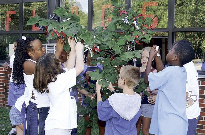 Fifth-graders from Thorpe Gordon Grade School hang ribbons from trees outside classrooms in September 2001. The entire school made ribbons and wore red, white and blue today to show support for America. Those who were children when the 9/11 attacks took place may have different views of the events than those who were adults. (File photo)