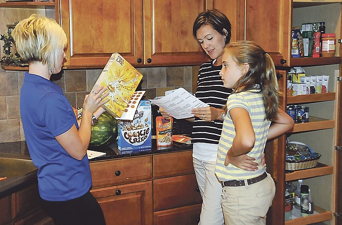 Amy Mason studies the ingredients list on a carton of Goldfish crackers. Generally, the shorter the list of ingredients, the better a product likely is for you.