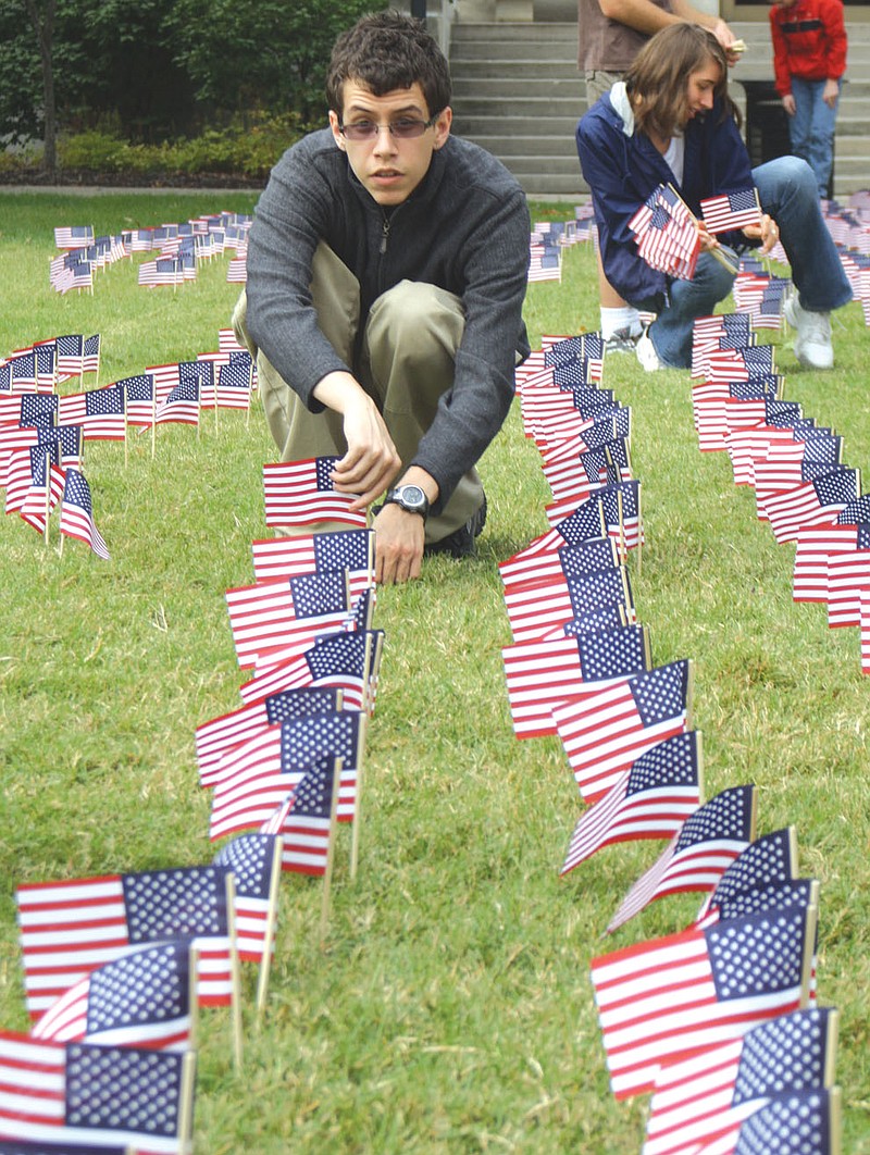 Cody Powers, senior at Westminster College, sets up flags at Latshaw Plaza Friday at the college. The College Republicans put up a flag for each victim of the 9/11 attacks, totaling 2,740 flags.