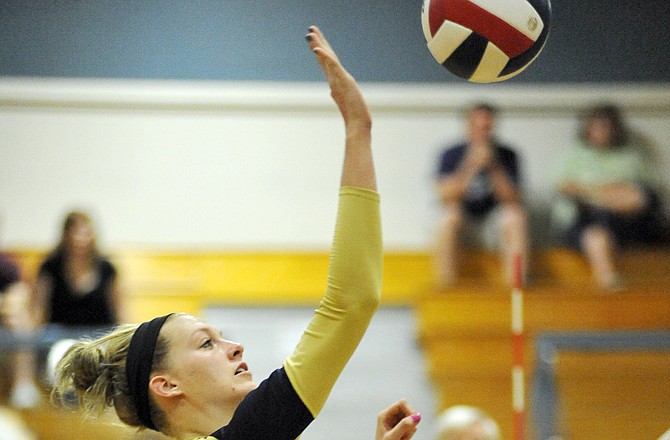 Krista Haslag of Helias tips the ball over the net for a point during Tuesday night's match against Boonville at Rackers Fieldhouse.