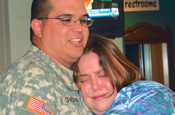 Heather Crespin holds tightly to her husband, Chris Crespin, after he came home Wednesday, surprising her at Diner 54.