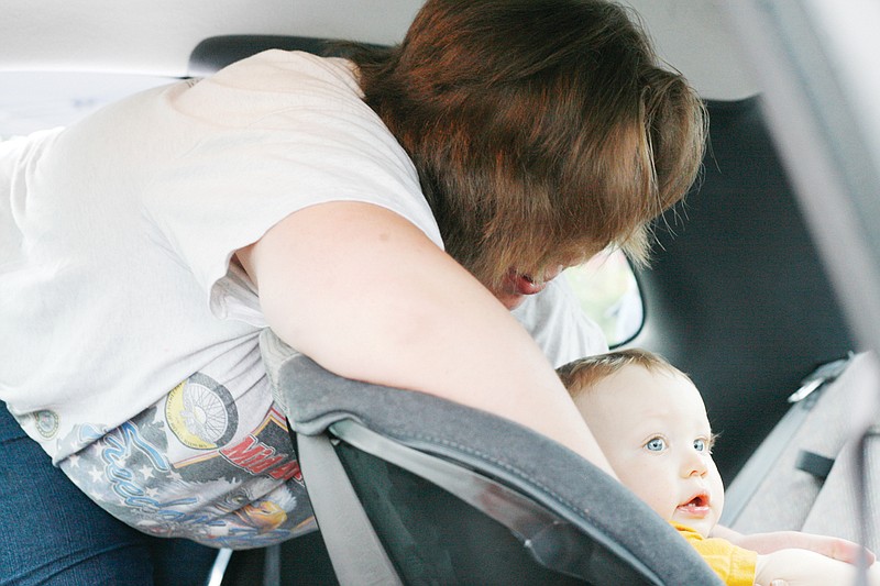 Tori Voisard buckles her son, Aiden, into his car seat after a Safe Kids child safety seat check conducted by the Callaway County Ambulance District and the Fulton Fire Department in Fulton in June 2010. Thanks to a grant from State Farm Insurance, the agencies now have a mobile child safety seat check station, enabling them to conduct car seat checks throughout Callaway.