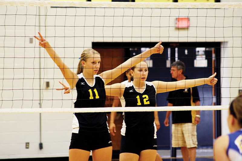 Fulton middle hitter Fern Stevermer (11) and outside hitter Bailey Mitchell - both juniors - flash defensive signals before a Fatima serve during Tuesday night's varsity match at Roger D. Davis Gymnasium. The Lady Hornets suffered their third straight loss, bowing to the Lady Comets 20-25, 25-10 and 25-22.