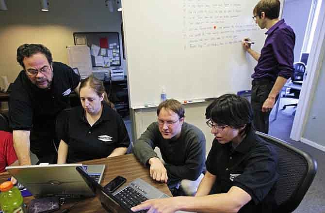 In this photo taken Sept. 8, 2011, Aspiritech co-founder Moshe Weitzberg, standing left, works with employees, from left, Katie Levin, Rick Alexander and Jamie Specht, at the nonprofit enterprise that specializes in finding software bugs as they test a new program in Highland Park, Ill. Aspiritech hires only people with autism disorders. Marc Lazar, Aspertech's autism specialist works in the background. 
